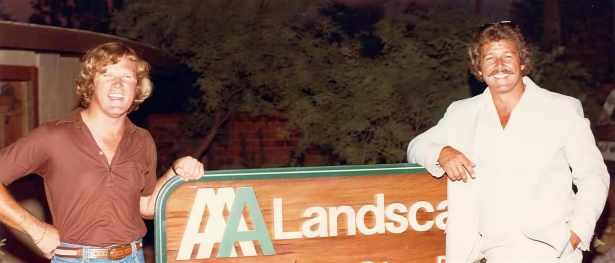 Bob and Richard Underwood stand beside an early AAA Landscape sign.